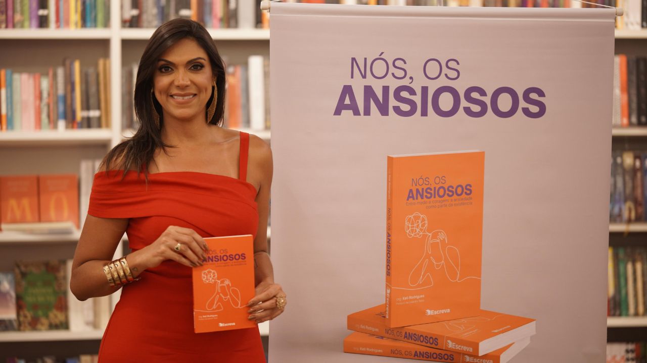 Carla de Castro segurando o livro Nós, os Ansiosos no lançamento